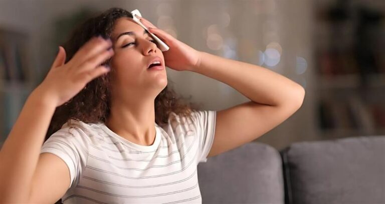 Woman Feeling Hot and Wiping Sweat From Forehead
